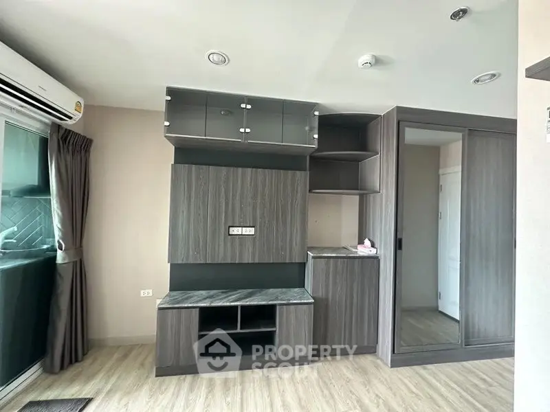 Modern apartment interior with sleek built-in storage and large window for natural light.