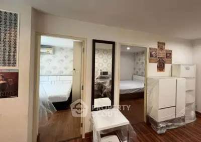 Spacious bedroom with modern decor and wooden flooring, featuring a large mirror and stylish wall art.