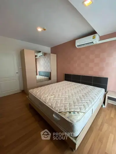 Spacious bedroom with modern design, featuring a large bed and stylish wardrobe.
