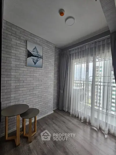 Modern living room with large windows and stylish decor in urban apartment.