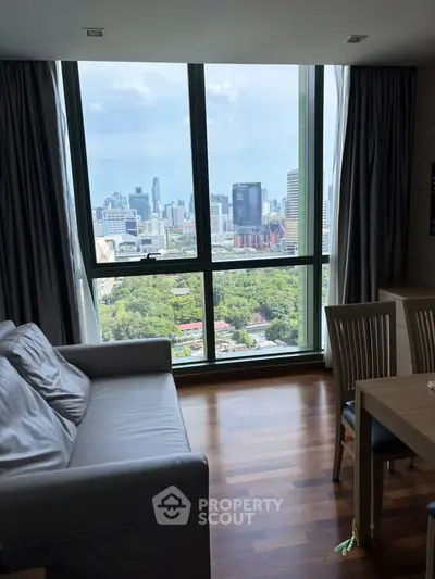 Stunning city view from modern living room with large windows and elegant furnishings.