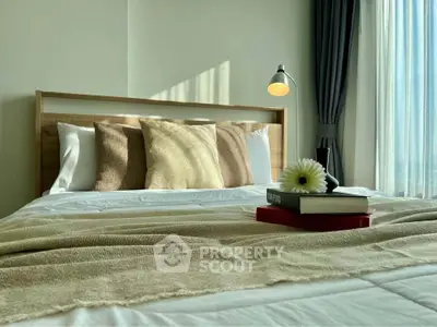 Cozy bedroom with natural light, stylish decor, and elegant bedding for a serene living experience.