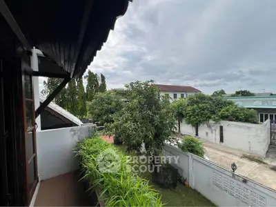 Charming balcony view with lush greenery and serene neighborhood setting.