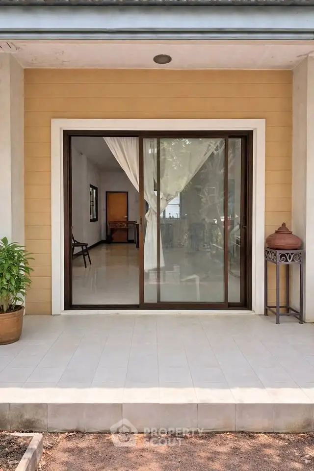 Charming patio entrance with sliding glass doors leading to a bright interior, perfect for seamless indoor-outdoor living.