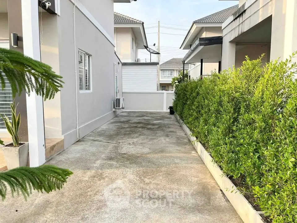 Charming exterior view of modern home with lush greenery and spacious driveway, perfect for family living.