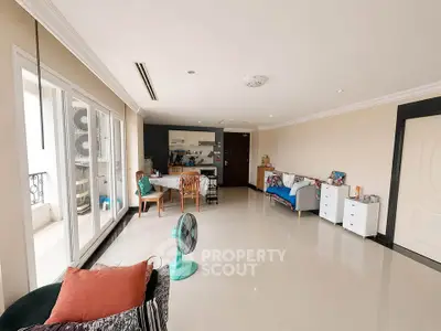 Spacious living room with open layout and balcony access, featuring modern decor and ample natural light.