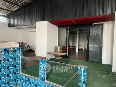 Spacious rooftop area with modern glass and tile design, perfect for entertainment and relaxation.