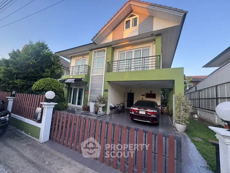 Charming two-story house with a carport and lush greenery in a serene neighborhood.