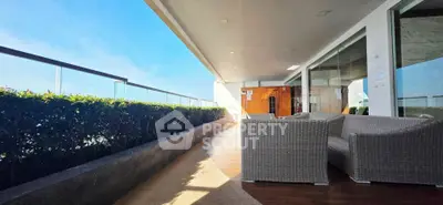 Spacious balcony with modern seating and stunning view, perfect for relaxation and entertainment.