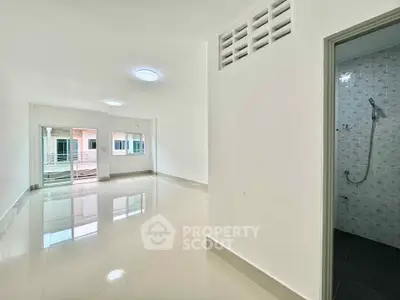 Spacious unfurnished apartment with glossy tiled floors and ample natural light.
