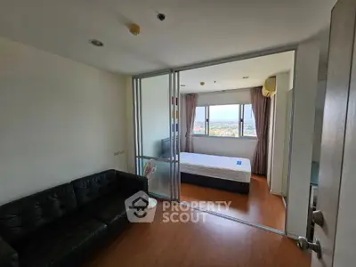 Modern apartment with cozy bedroom and spacious living area, featuring large windows with a scenic view.