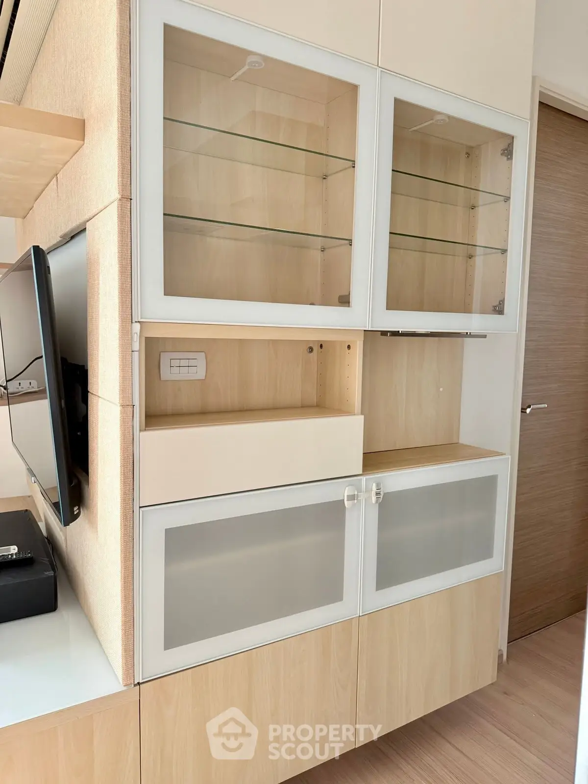 Modern living room with sleek wooden cabinets and built-in TV unit
