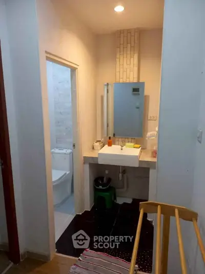 Compact bathroom with modern sink and toilet, featuring a minimalist design and efficient use of space.