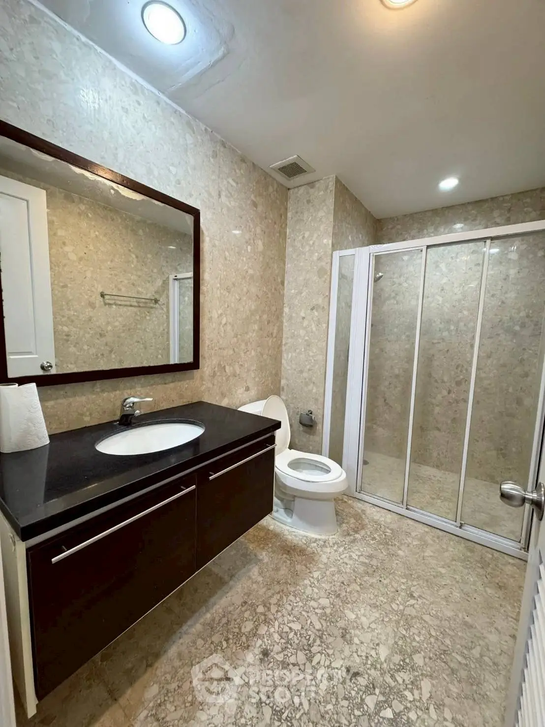 Modern bathroom with sleek fixtures and spacious shower in a luxury apartment.