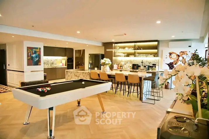 Luxurious open-plan living area with pool table and modern kitchen, perfect for entertaining.