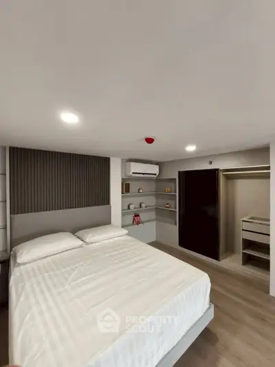 Modern bedroom with sleek design, featuring built-in shelves and a spacious wardrobe.