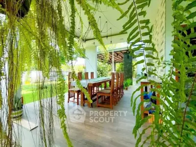 Stunning outdoor dining area with lush greenery and elegant wooden furniture.