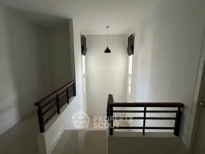 Modern staircase with sleek railing and pendant light in minimalist home interior