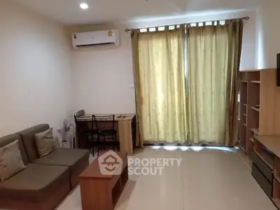 Cozy living room with air conditioning and natural light, perfect for relaxation.