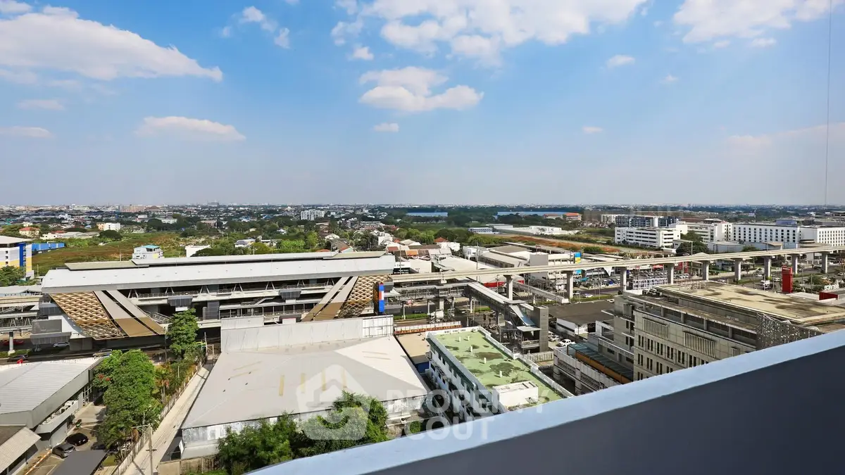 Stunning cityscape view from a high-rise balcony overlooking urban infrastructure and skyline.