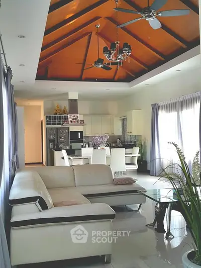 Spacious living room with high wooden ceiling and modern furniture