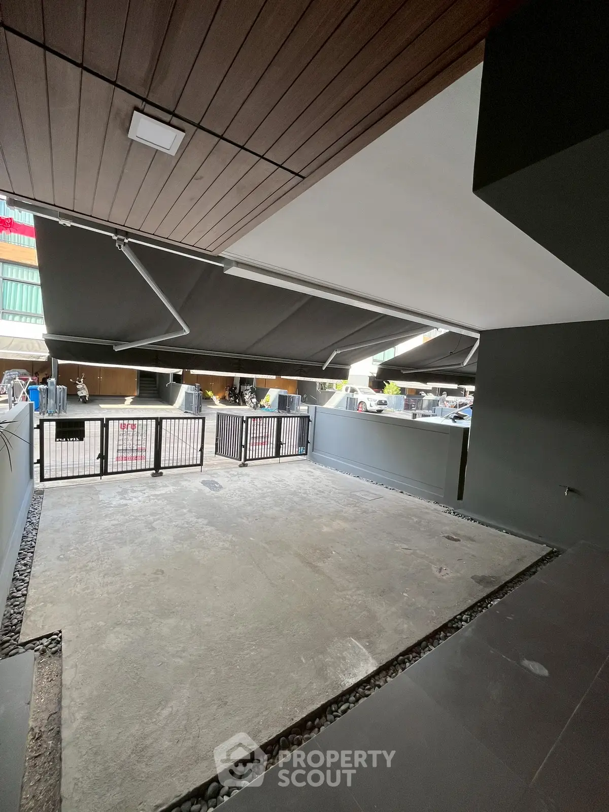 Spacious covered parking area with modern design and secure gated entrance.