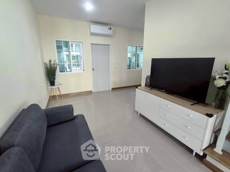 Modern living room with sleek furniture and large TV, perfect for relaxation.