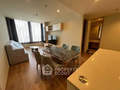 Modern living room with dining area, stylish furniture, and large windows for natural light.