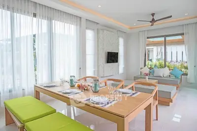 Bright and modern living room with dining area, large windows, and stylish decor.