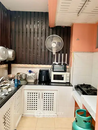 Cozy kitchen with gas stove and modern appliances, perfect for culinary enthusiasts.