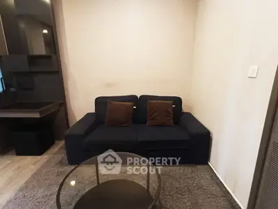Cozy living room with dark sofa and modern decor in a stylish apartment.