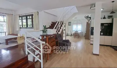 Spacious open-plan living area with modern staircase and dining space.