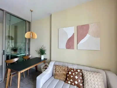 Modern living room with stylish decor and dining area, featuring elegant lighting and contemporary art.