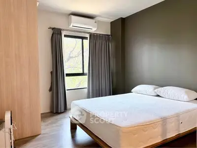Modern bedroom with large window and minimalist decor, featuring a comfortable bed and air conditioning.