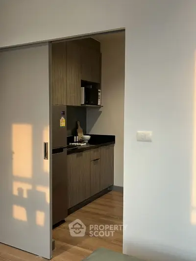Modern compact kitchen with sleek cabinetry and wood flooring