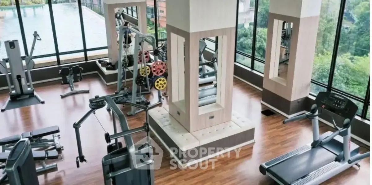 Modern gym with state-of-the-art equipment and panoramic views in luxury building.