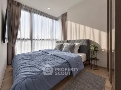 Modern bedroom with large windows, stylish decor, and natural light.