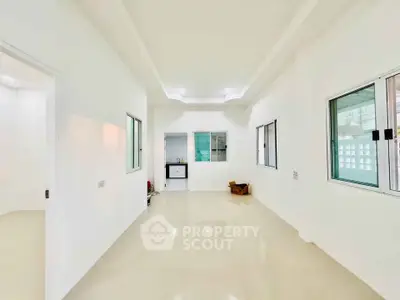 Spacious white-walled interior with glossy floors and large windows, perfect for modern living.
