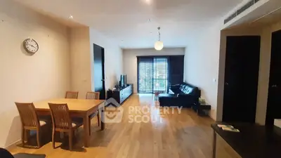 Spacious living room with wooden flooring and modern furniture in a cozy apartment.