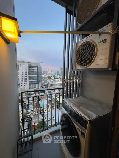 Modern high-rise balcony with city view, featuring laundry area and air conditioning unit.