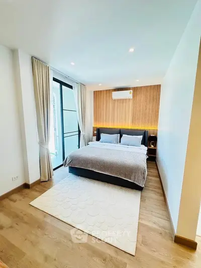Modern bedroom with wooden accents and natural light in luxury apartment.