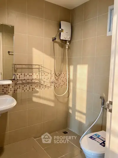 Modern bathroom with shower, toilet, and tiled walls in a real estate property.