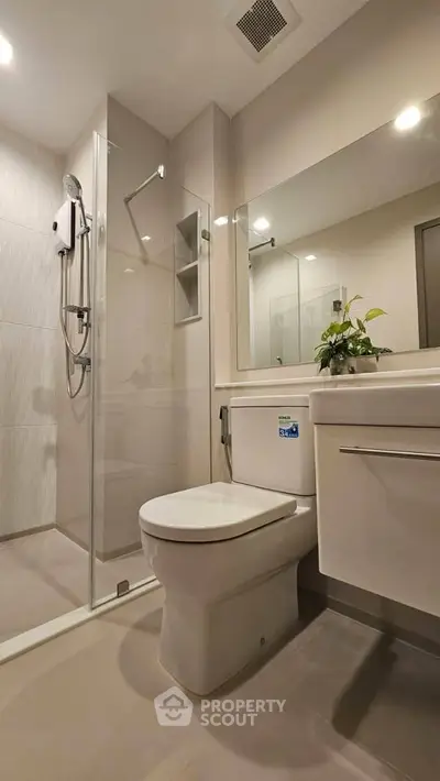 Modern bathroom with glass shower and sleek fixtures in a contemporary apartment.