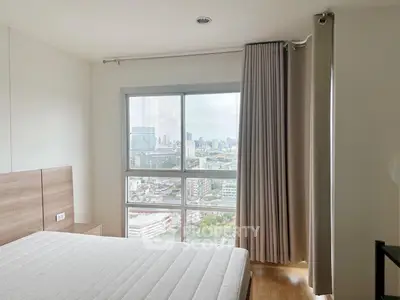 Bright bedroom with large window offering stunning city view, featuring modern design and cozy ambiance.