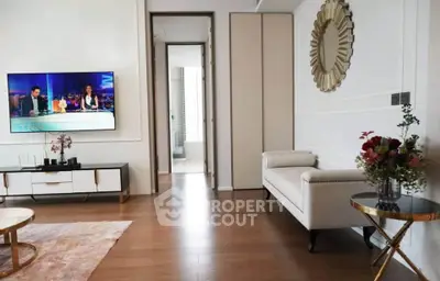 Elegant living room with modern decor and wall-mounted TV, featuring stylish furniture and floral accents.