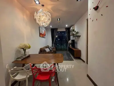 Modern living room with stylish chandelier and city view window, featuring contemporary furniture and decor.