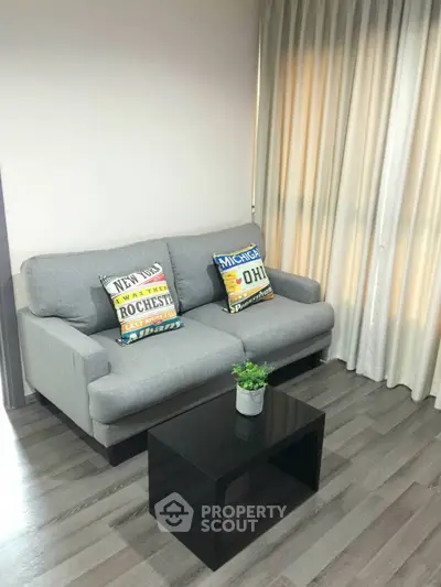 Cozy living room with modern gray sofa and stylish black coffee table.
