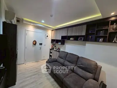 Modern living room with cozy sofa and stylish shelving, featuring ambient lighting and sleek wooden flooring.