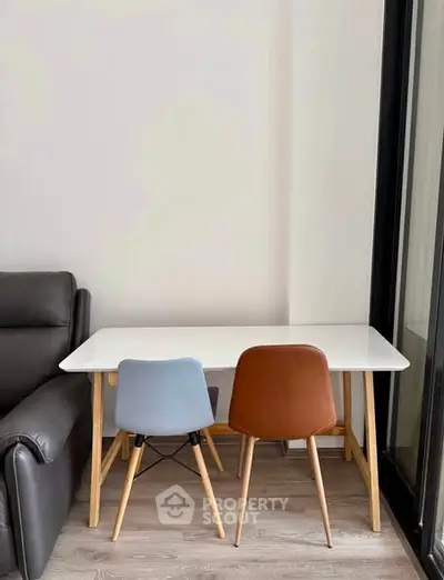 Modern dining area with sleek table and stylish chairs in a cozy living space.