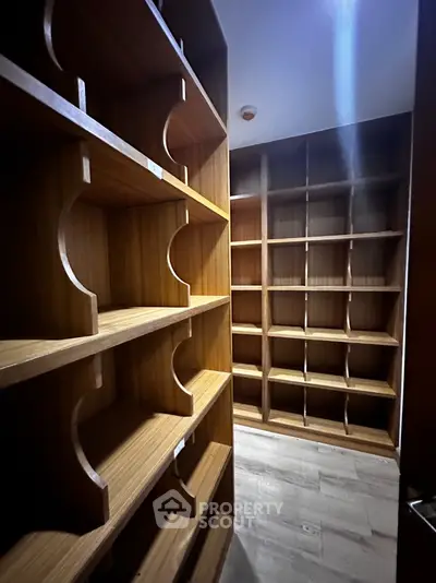 Spacious wooden storage room with ample shelving for organization.